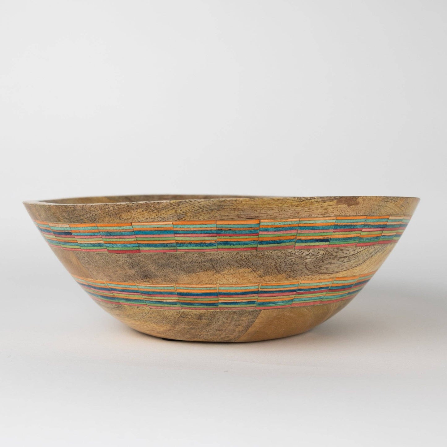 Wooden bowl with multicolored striping on a white background