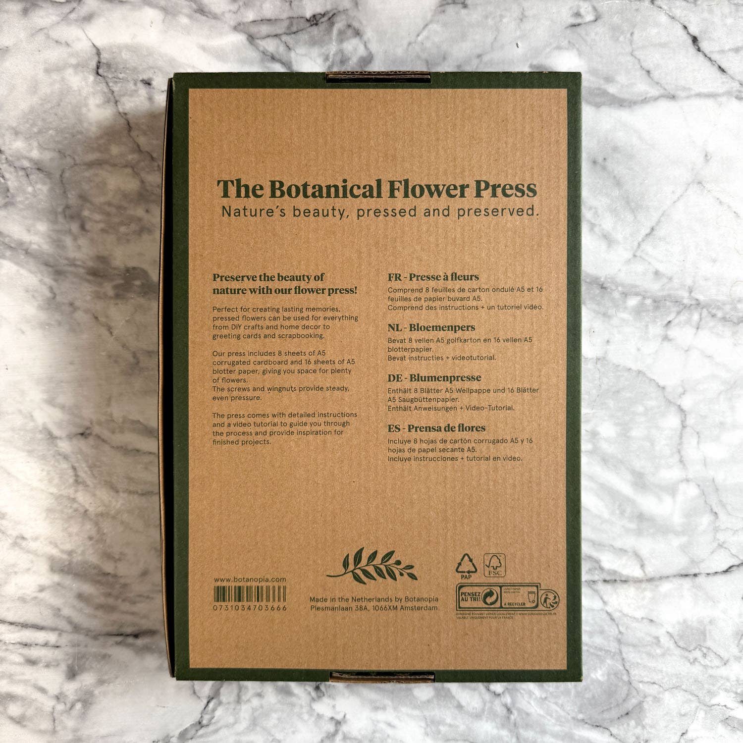 Box labeled 'The Botanical Flower Press' on a marble surface