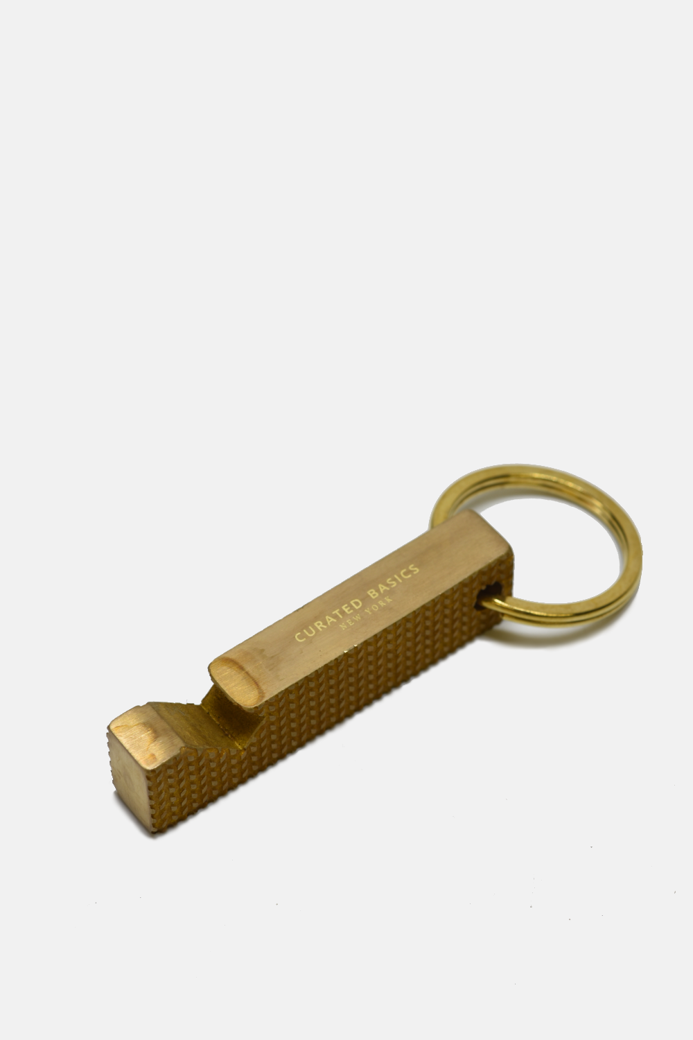 A gold-colored metal keychain tool with a textured grip and a split key ring, featuring the brand name 'CORED UP TOCKS' engraved on its side, set against a plain light gray background.