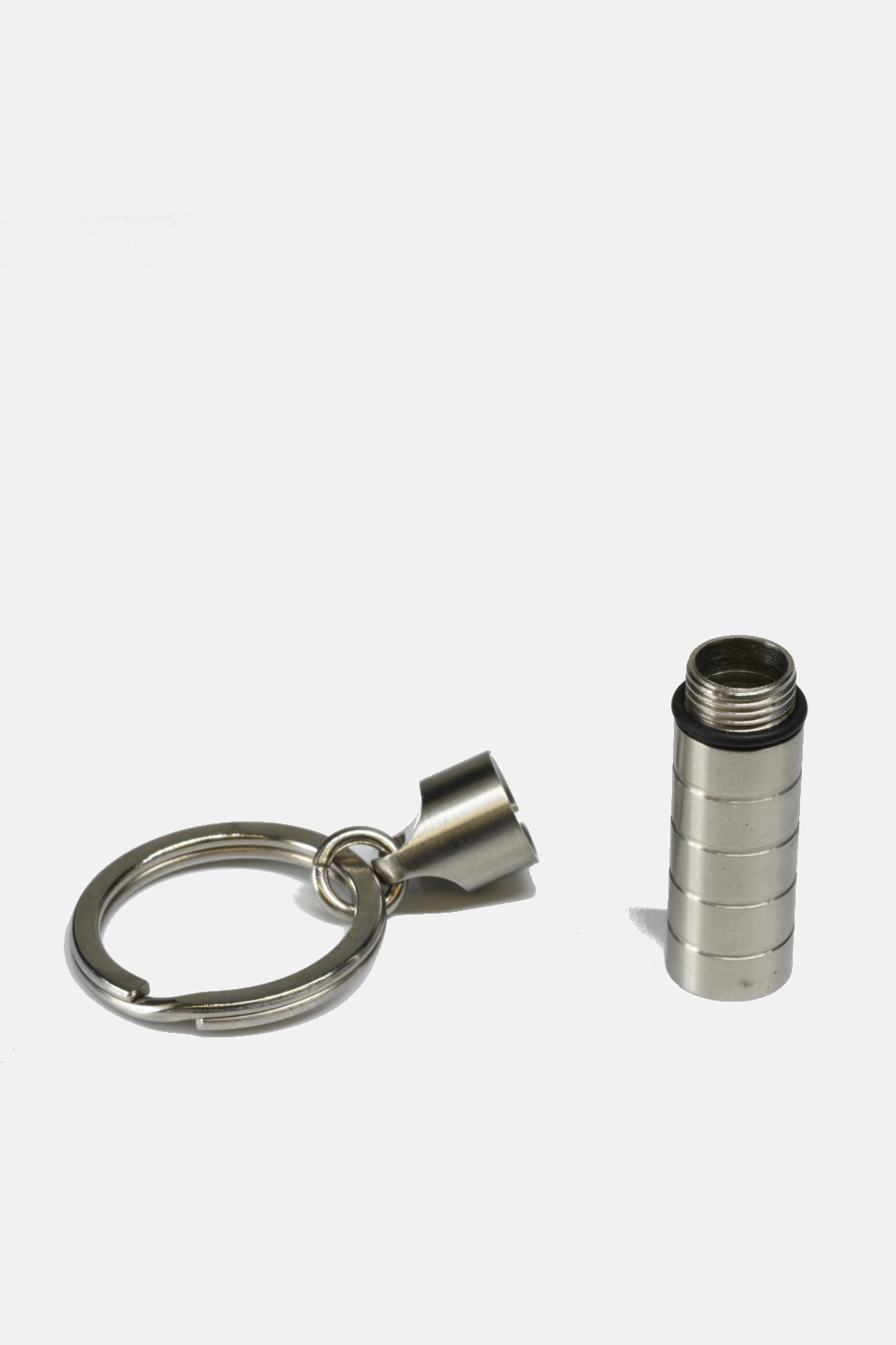 Metallic keychain and cylindrical container on a white background