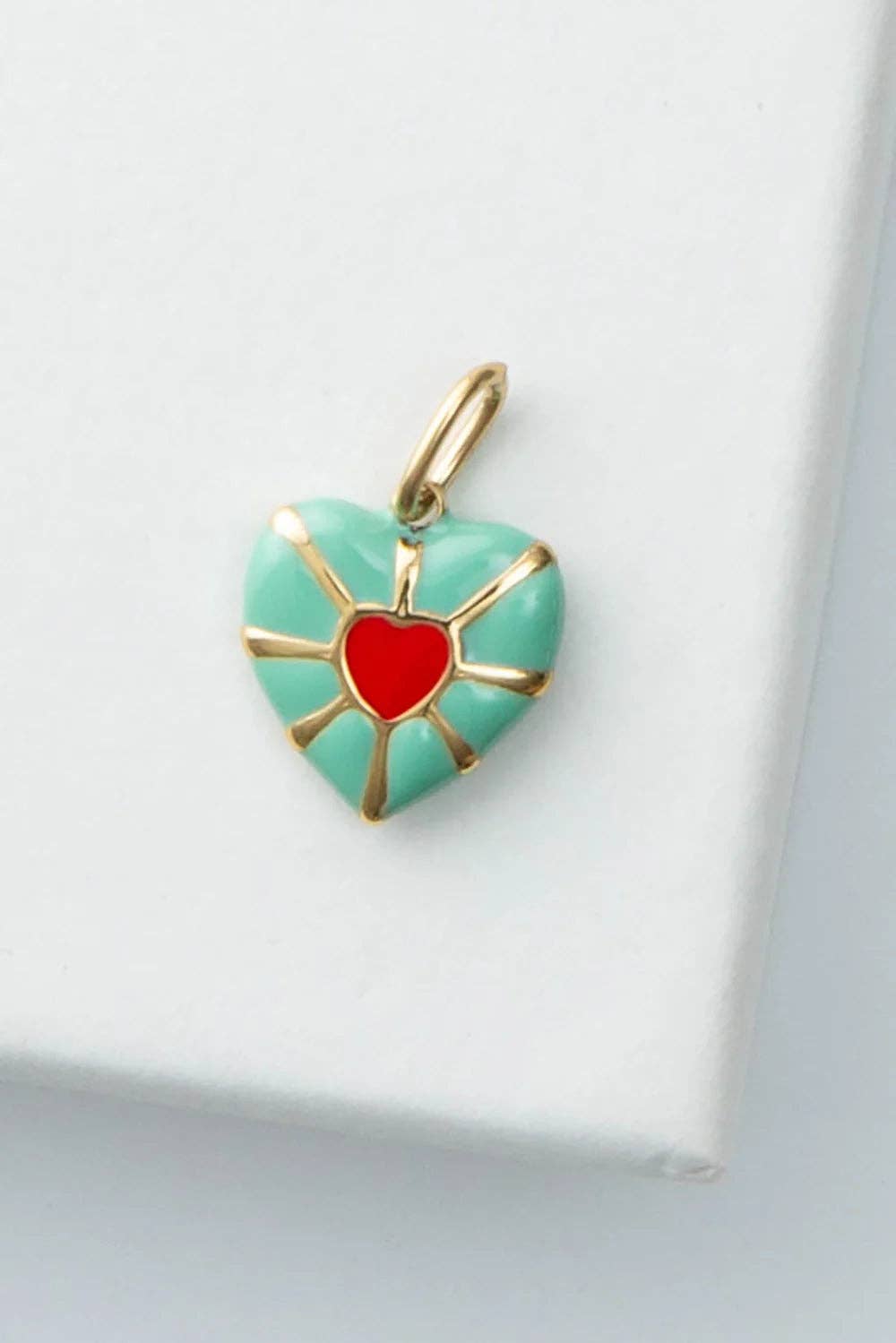 Heart-shaped pendant with red center and gold accents on a white background