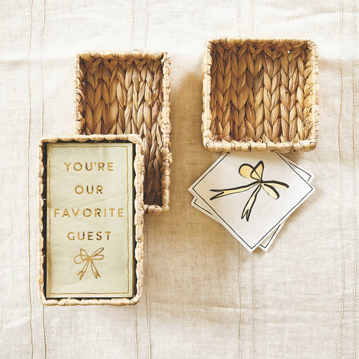 Woven baskets and a card with 'You're our favorite guest' text on a textured surface