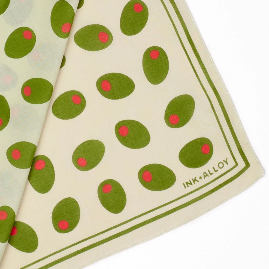 Folded fabric with green and red pattern and 'INK+ALLOY' branding on a white background