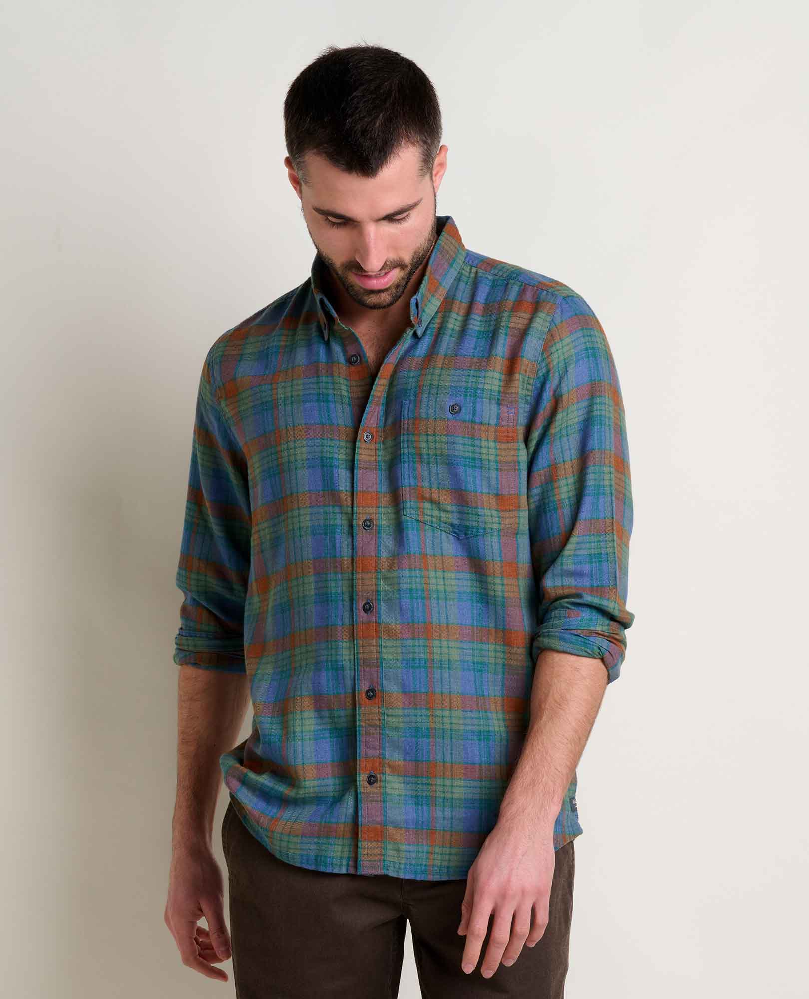 Man wearing a plaid shirt against a plain background