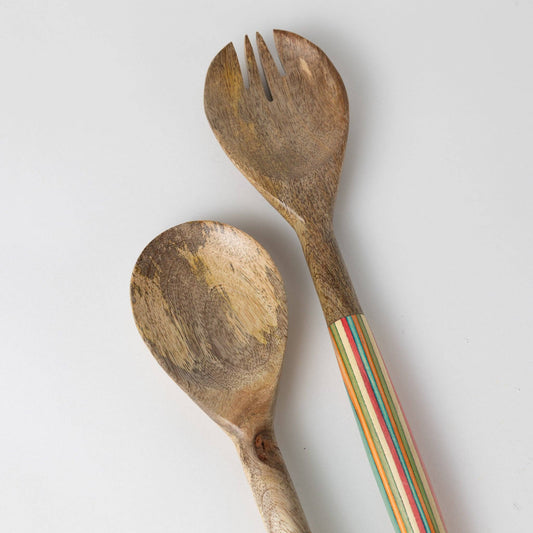 Wooden spoon and fork with a colorful handle on a light gray background