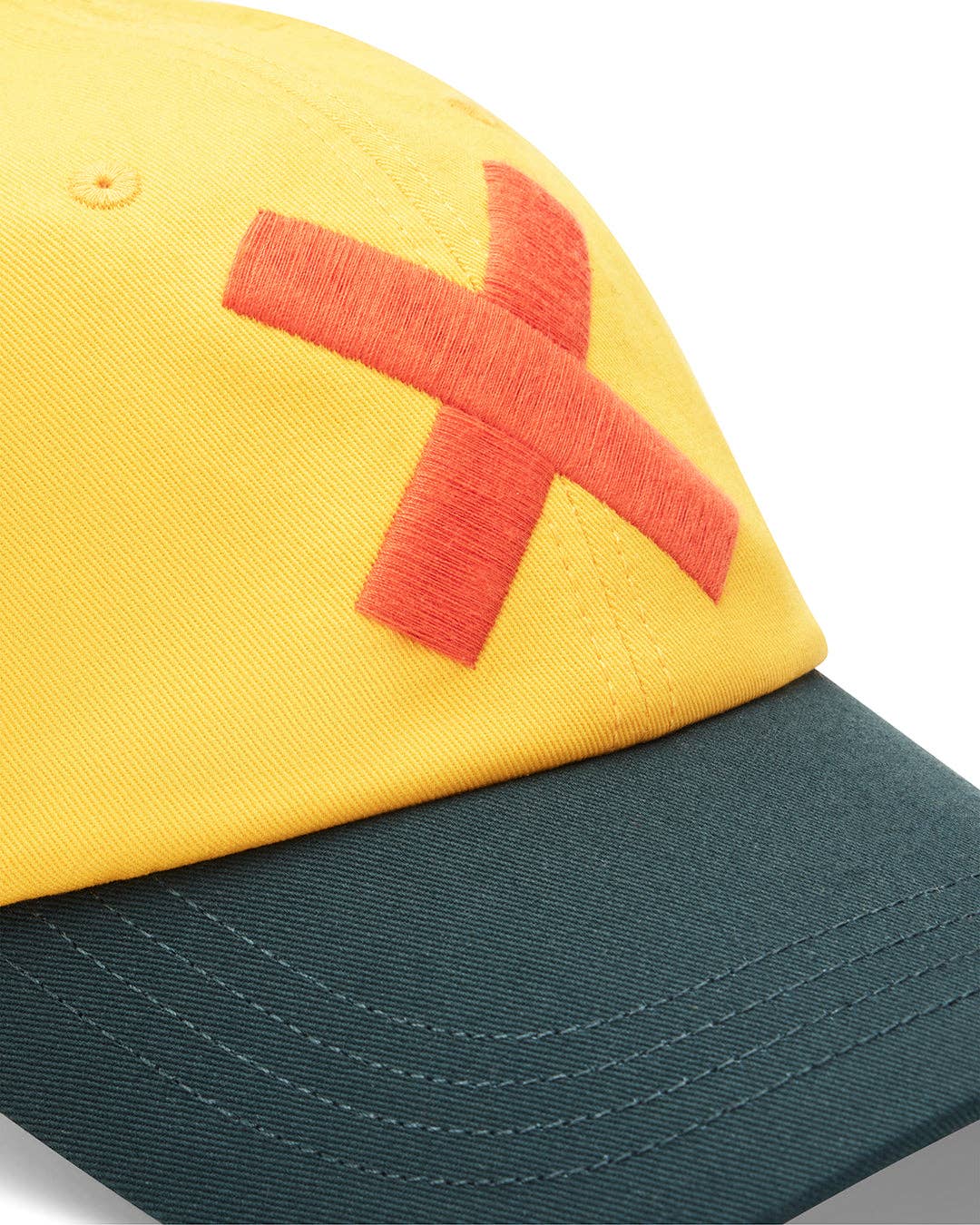 Yellow and green cap with a red 'X' on a white background