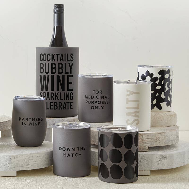 Collection of wine glasses with various text designs on a wooden surface.