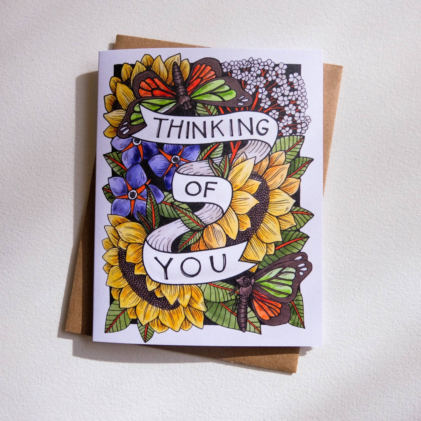 Greeting card with floral design and 'Thinking of You' text on a white background