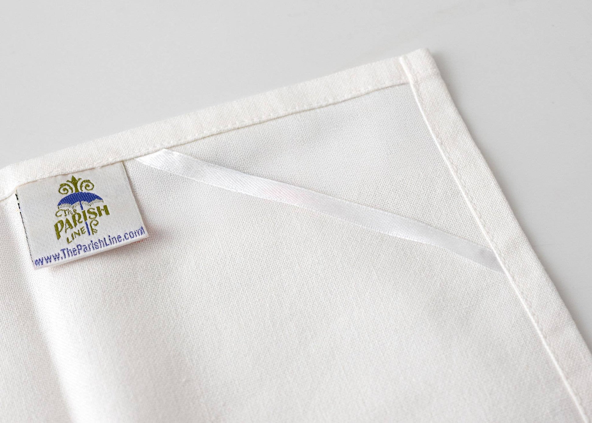 White fabric with a visible brand label on a light gray background