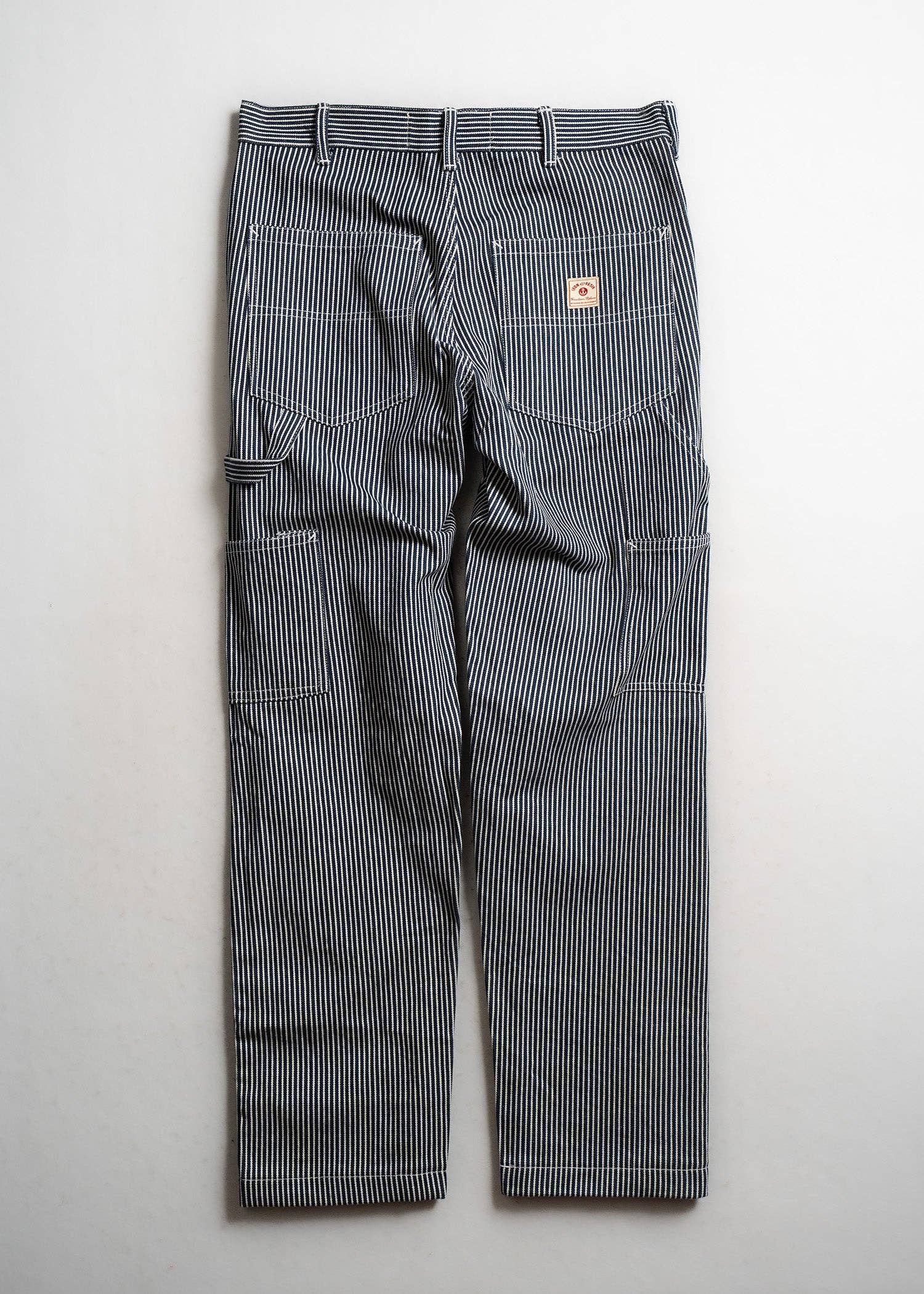 Gray striped work pants with a brand logo on a light gray background