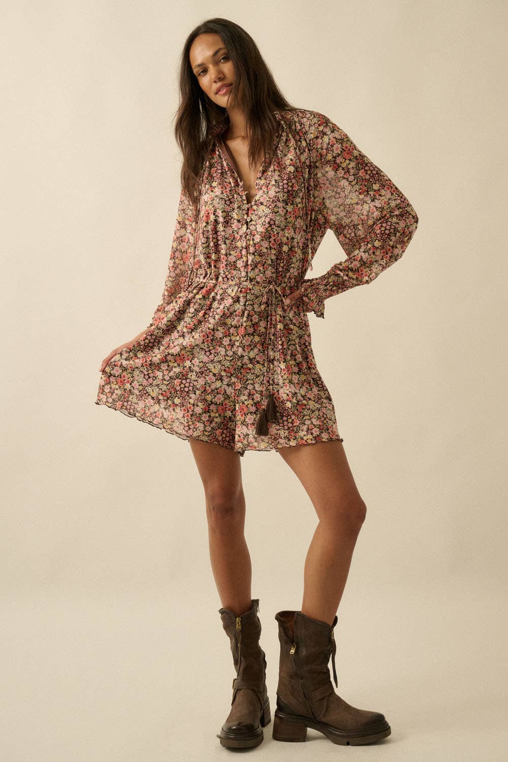 Woman wearing a floral dress and boots on a beige background