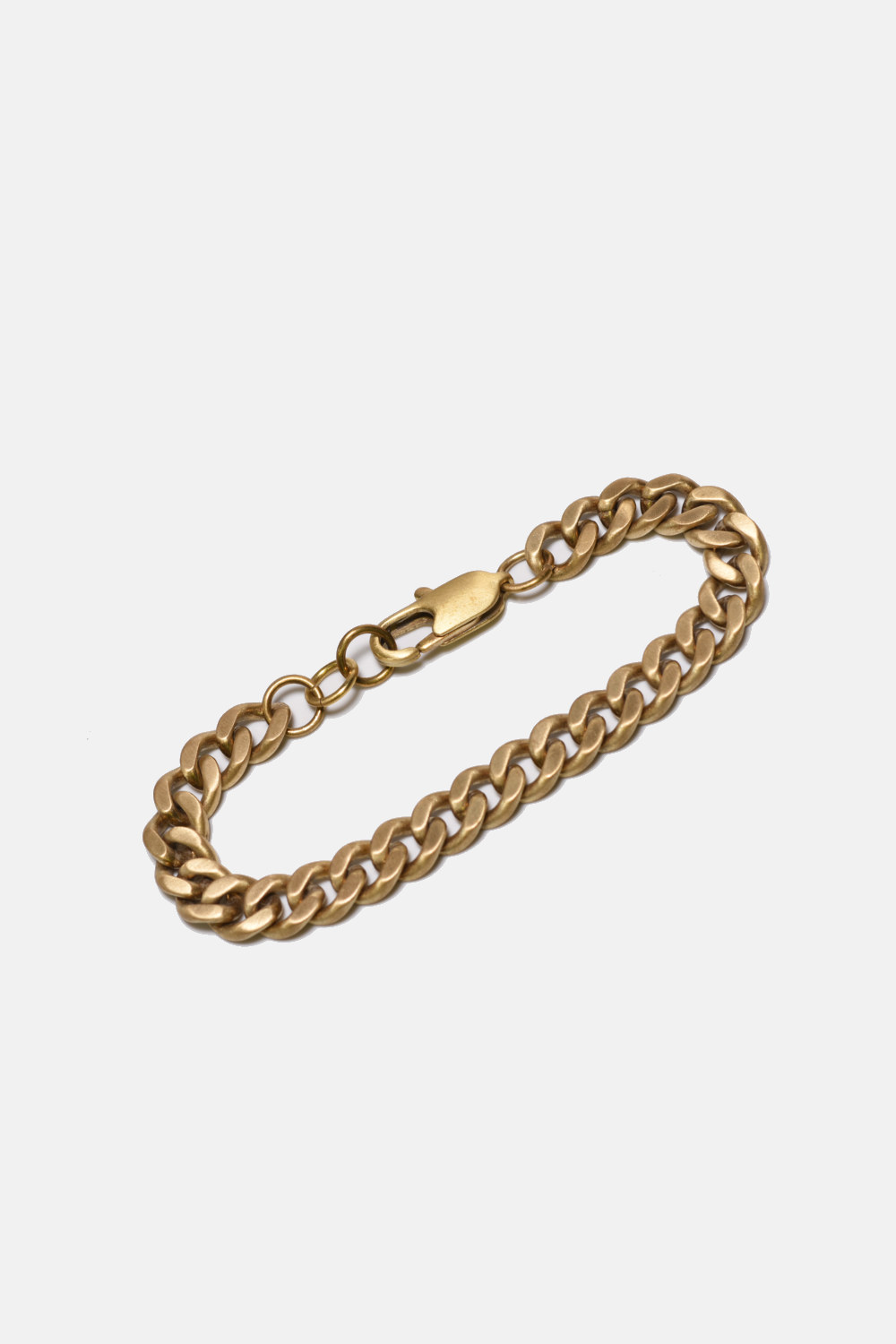Gold chain bracelet on a light gray background