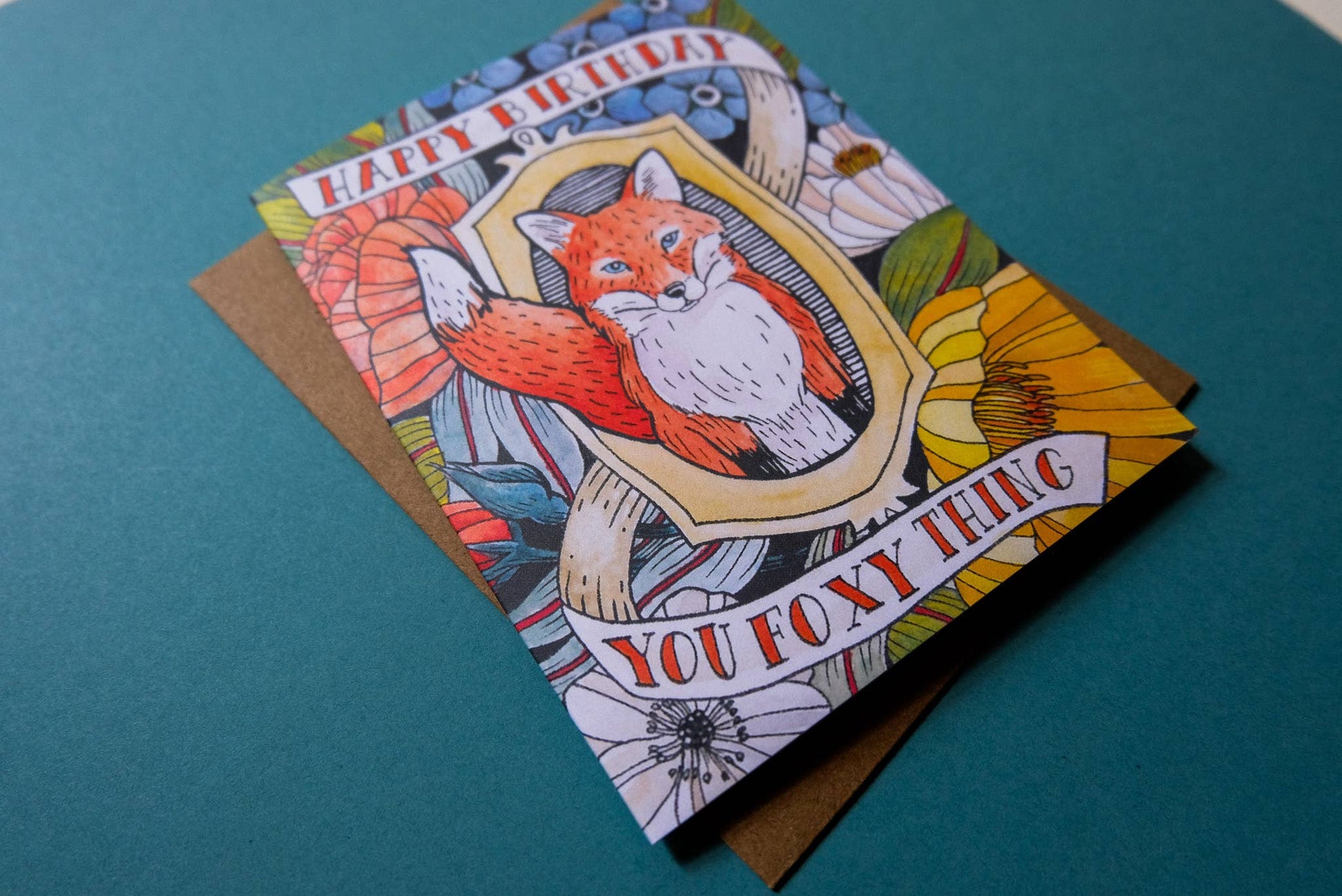 Birthday card with fox illustration and text on a teal background