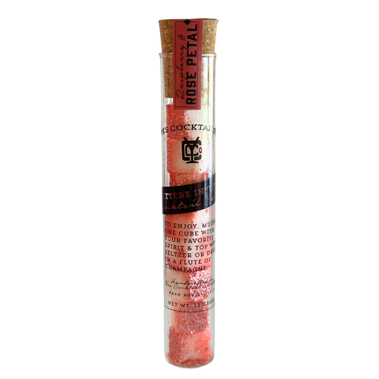 Cocktail rose petal mix in a glass tube with cork lid on a white background