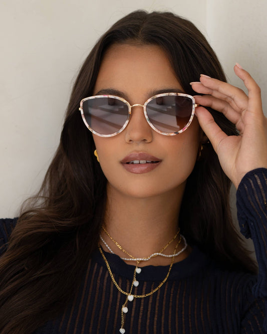 Woman wearing sunglasses with a neutral background