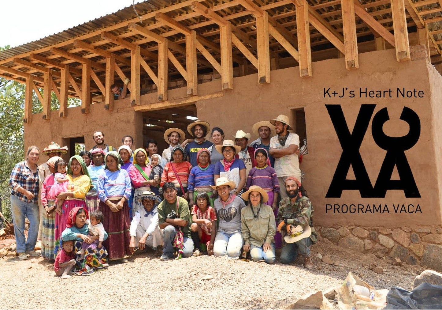 Group of people in front of a wooden structure with K+J's Heart Note Programa Vaca logo.