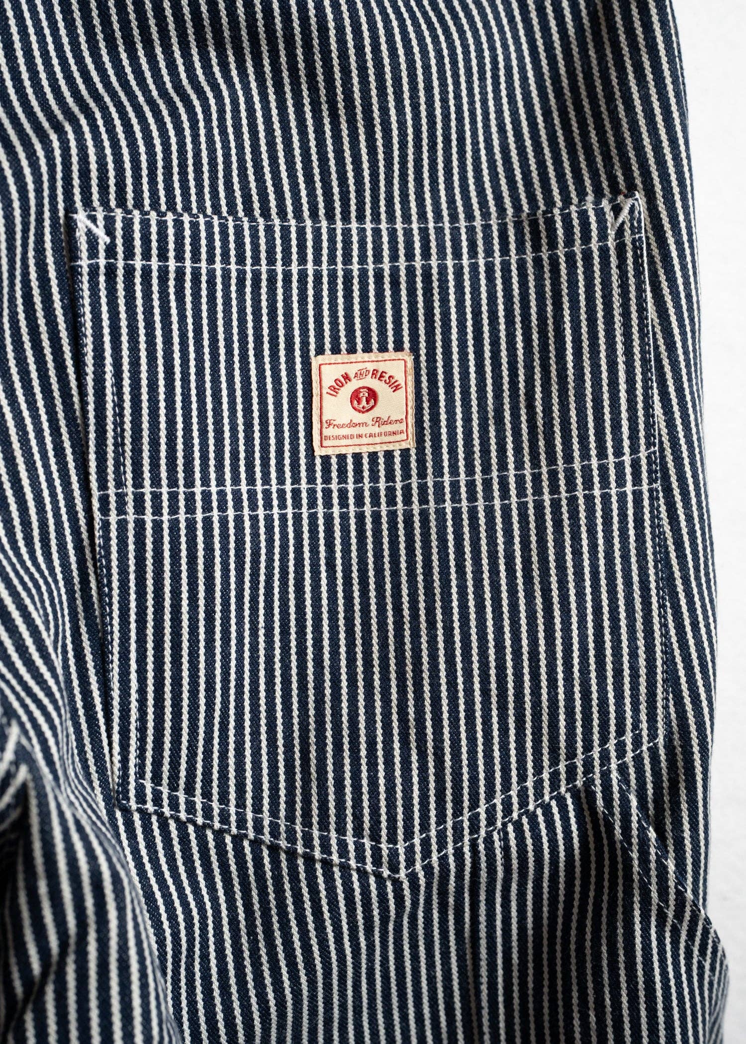 Close-up of a black and white striped shirt with a brand label on the chest pocket.