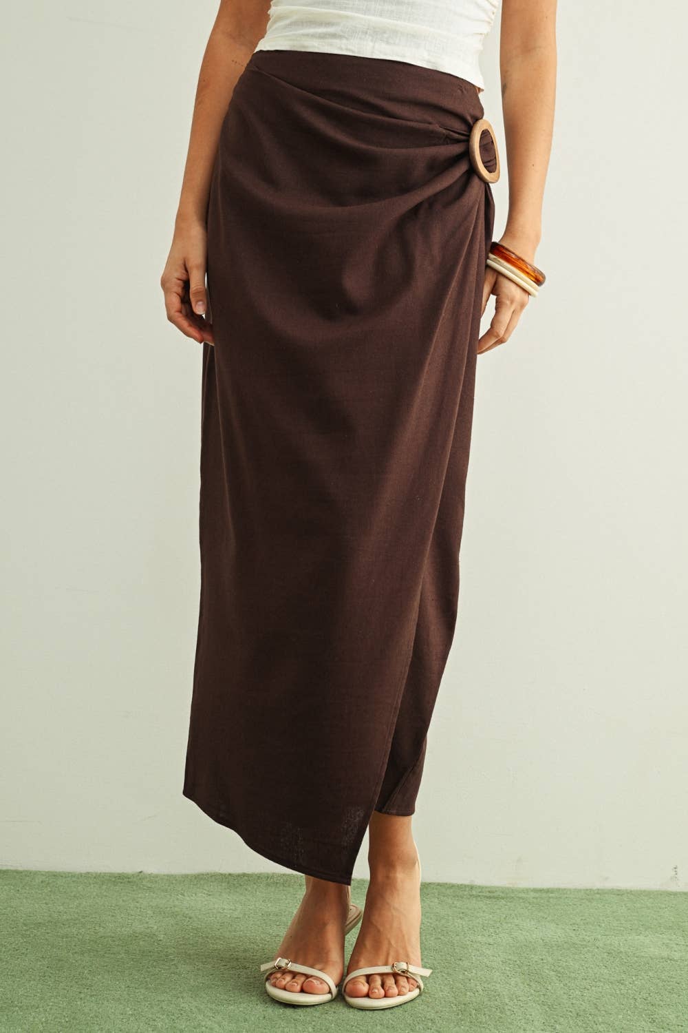 Brown wrap skirt worn by a person on a plain background