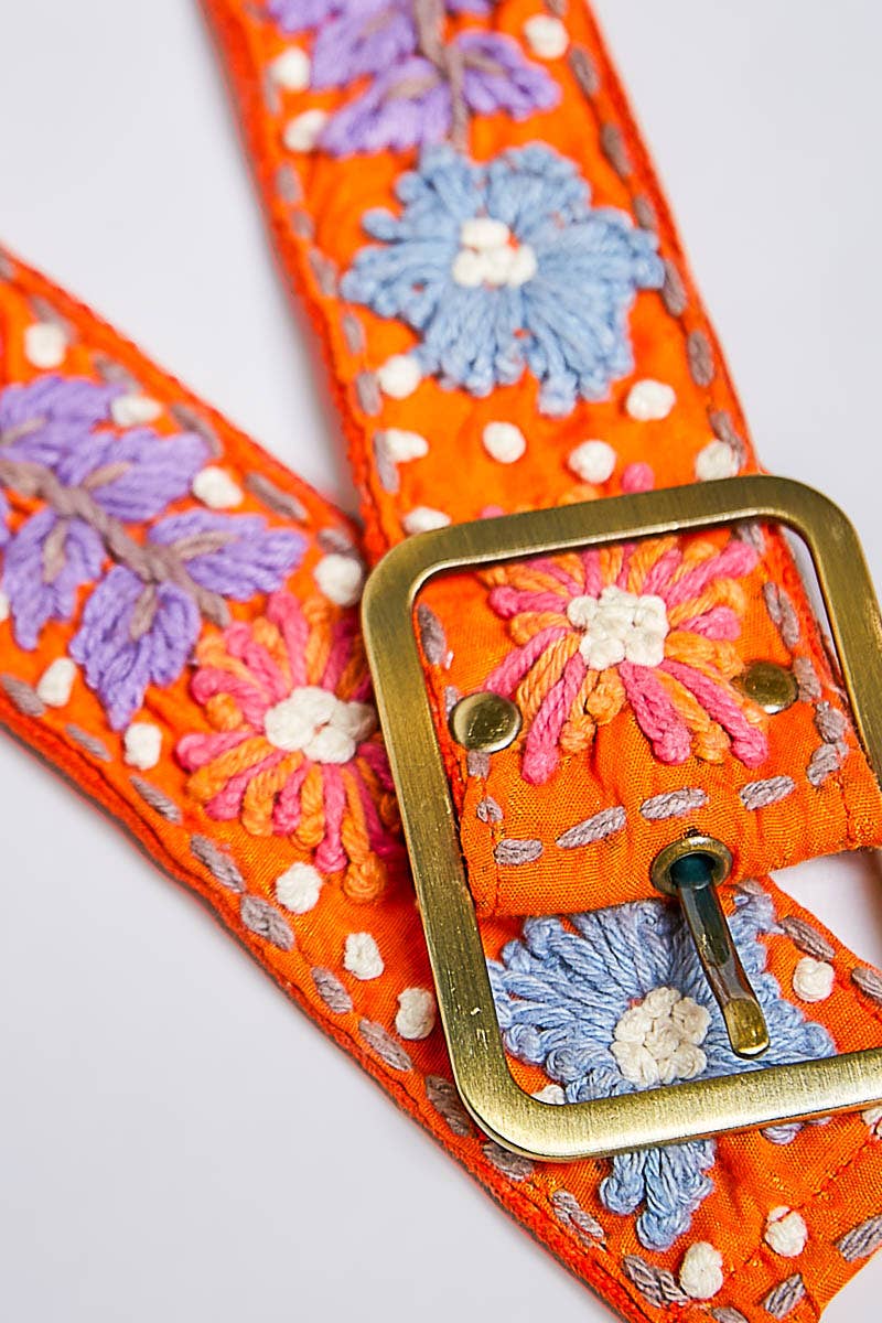 Orange belt with floral embroidery and a gold buckle on a white background