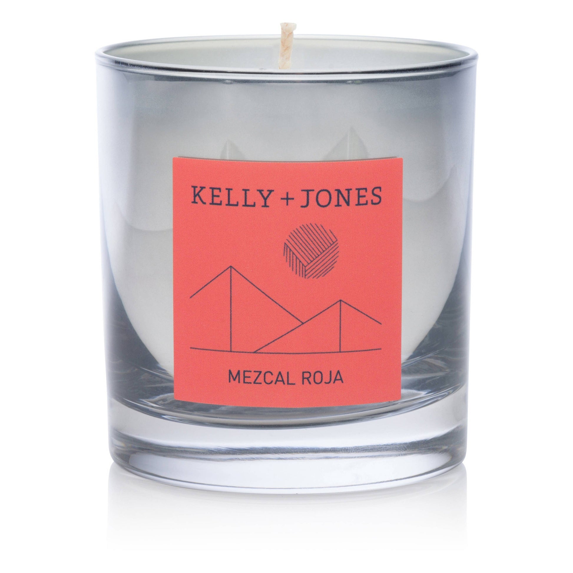 Glass candle with a red label featuring 'Kelly + Jones' and 'Mezcal Roja' on a white background