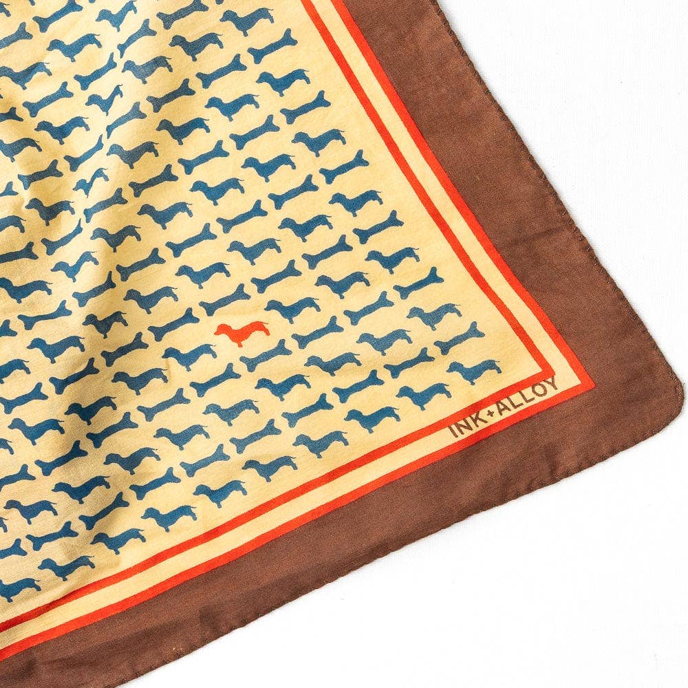 Patterned fabric with dog design and 'INK+ALLOY' branding on a white background