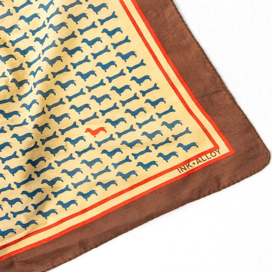 Patterned fabric with dog design and 'INK+ALLOY' branding on a white background