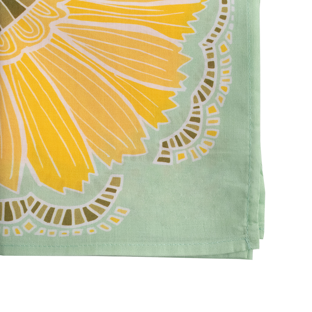 Folded fabric with yellow floral design on a green background