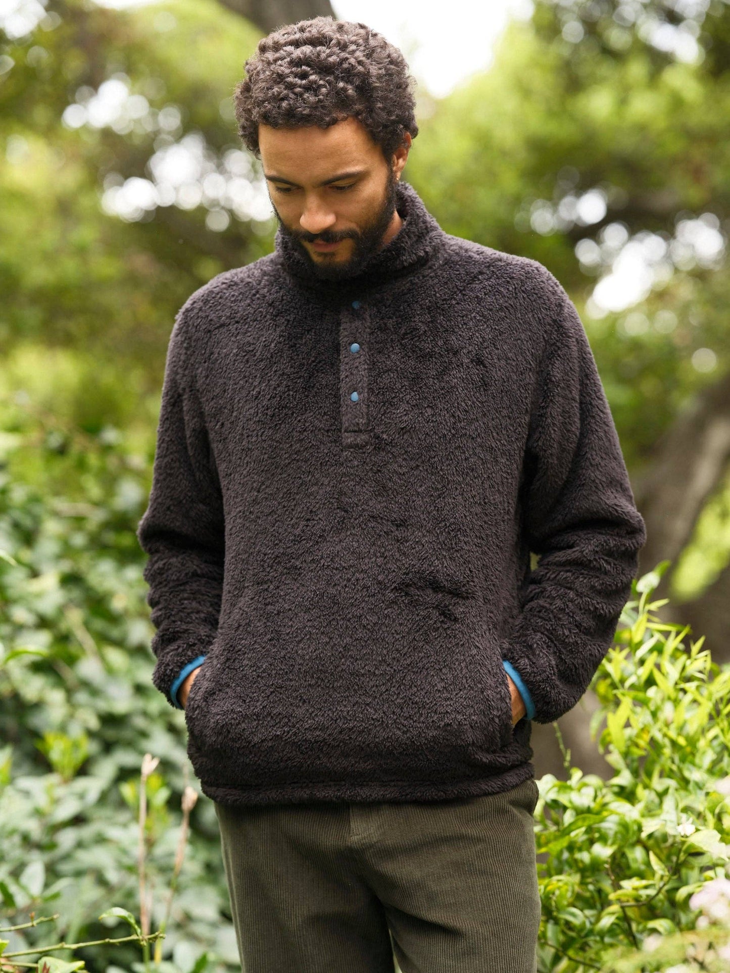 Man wearing a dark fleece pullover in a forest setting