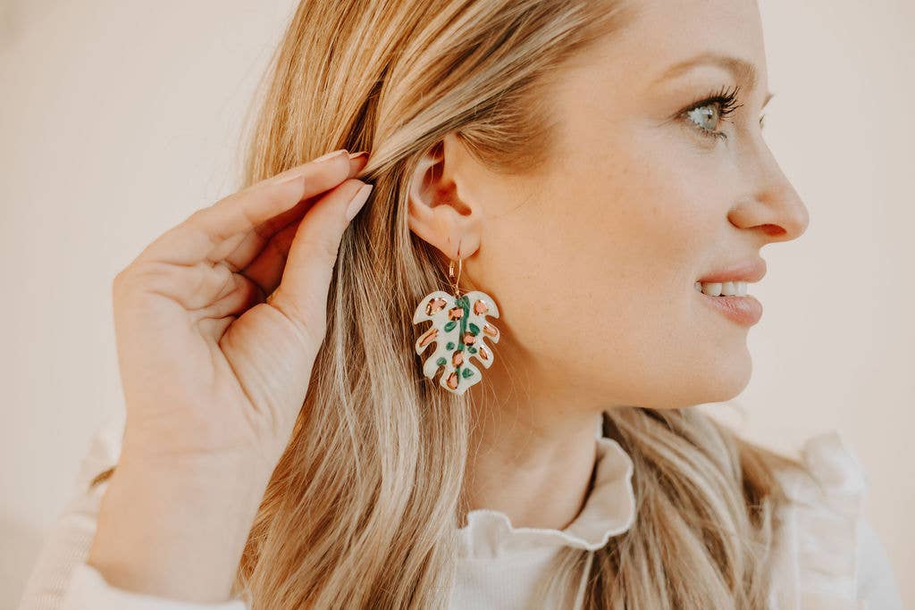 Woman wearing a leaf-shaped earring with a blurred background