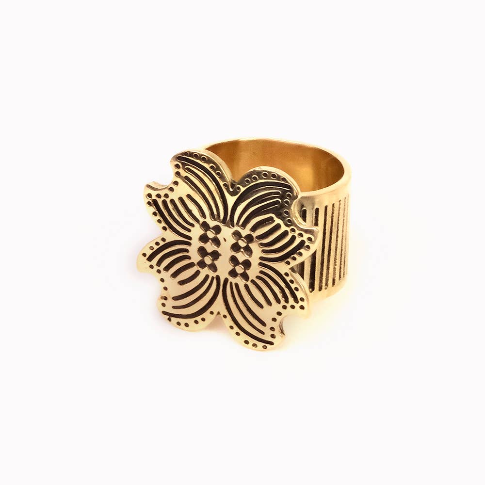 Gold ring with intricate floral design on a white background