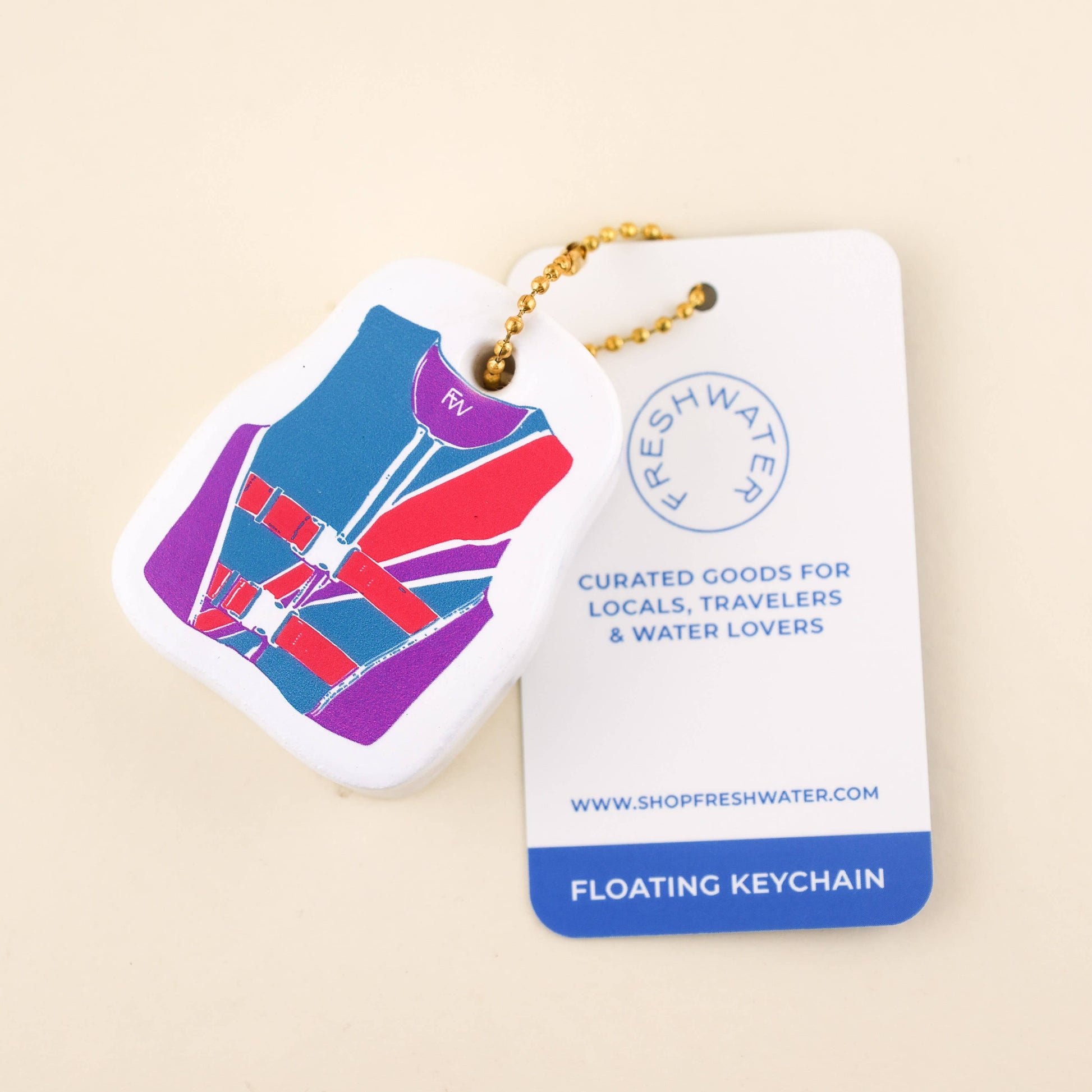 Floating keychain with a colorful design on a beige background