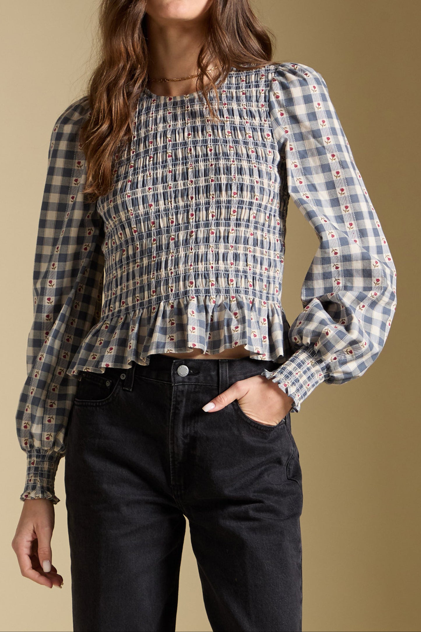 Woman wearing a plaid shirt with a beige background