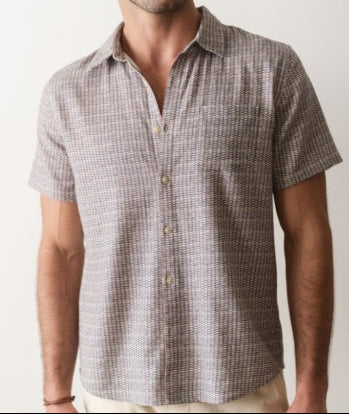 Man wearing a checkered short-sleeve shirt against a plain background