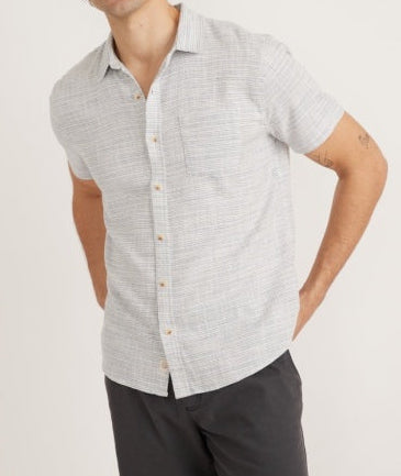 Man wearing a light gray short-sleeve shirt with a subtle pattern on a white background