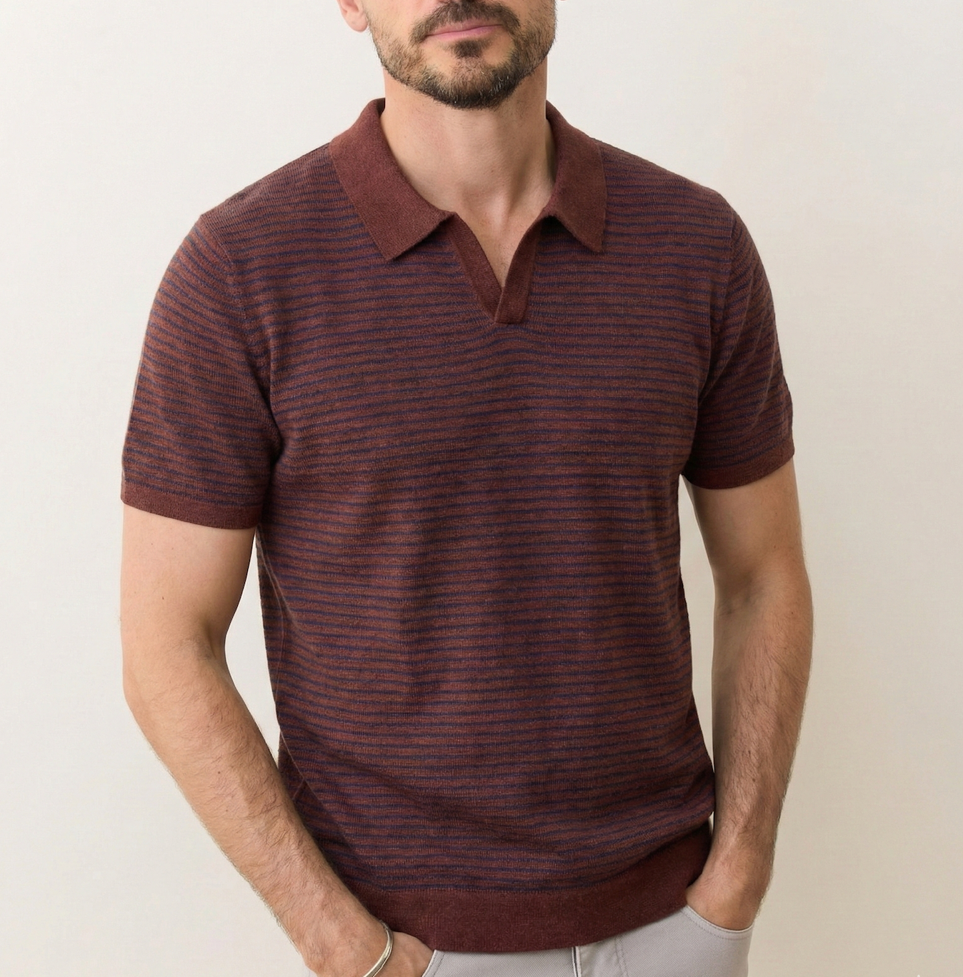 Man wearing a brown striped polo shirt against a plain background