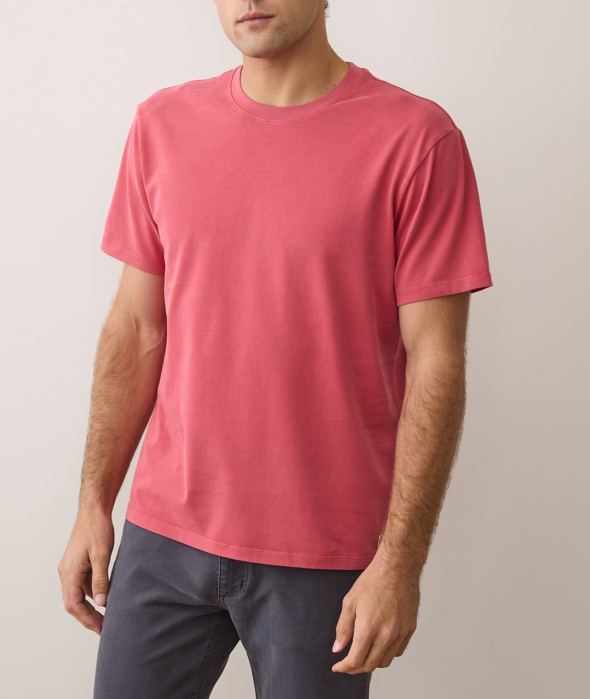 Man wearing a pink t-shirt against a plain background